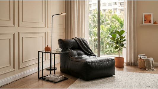 Black leather reading chair in a modern Singapore home with side table, floor lamp, balcony greenery, and cosy lounge corner
