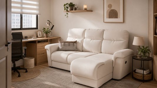 Cream sofa bed in a compact Singapore guest room with home office setup, warm wood storage, soft daylight, and practical HDB styling.