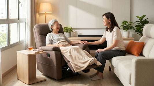 Daughter sitting beside her elderly mother resting in a recliner chair in a bright Singapore living room, showing practical furniture for caring for elderly parents at home.