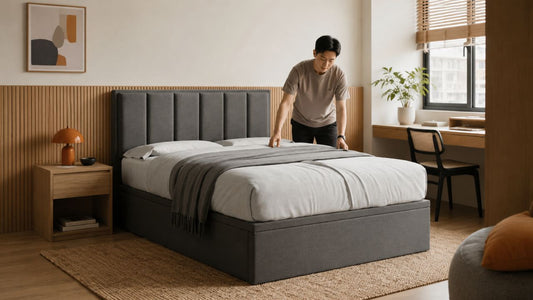 Male Chinese Singaporean arranging a bamboo cover mattress on a grey upholstered bed in a modern bedroom