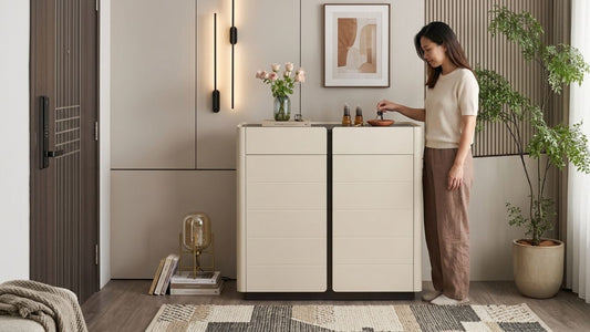 Modern cream display cabinet collection in a minimalist living room with warm lighting, wood panel wall accents, indoor plant styling, and contemporary neutral decor