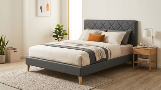 Grey PU leather bed frame with diamond-tufted headboard in a modern Singapore bedroom with wooden bedside table and neutral bedding