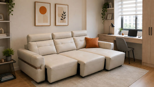 Cream single sofa bed styled in a compact Singapore home office with warm wood storage, soft daylight, and a pumpkin orange cushion accent.