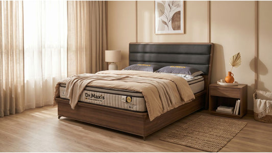 Soft pillow-top mattress styled in a modern Singapore bedroom with dark headboard, wood bed frame, and neutral bedding