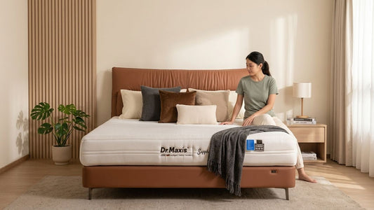 Modern bedroom styled with layered throw pillows in different sizes and fill types on a leather bed frame for cosy and supportive sleep décor inspiration