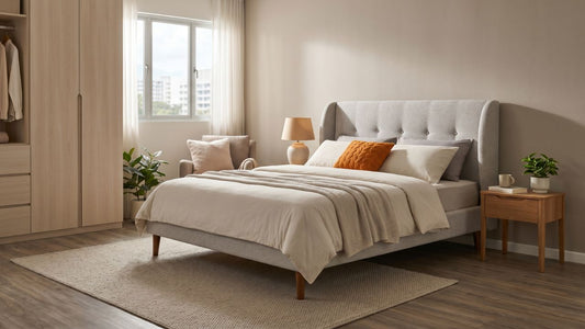 Upholstered bed frame with fabric headboard in a warm Singapore bedroom with bedside table, soft bedding, and natural daylight.